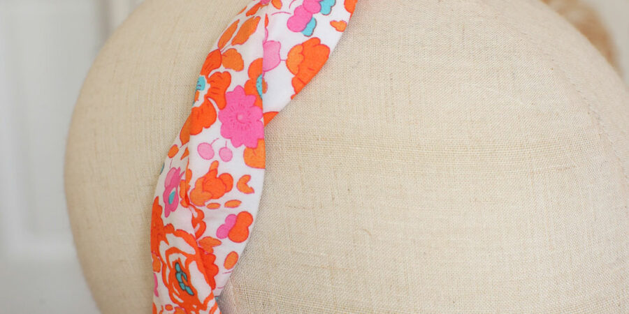 Serre-tête tressé Isaure Marie Joséphine en Liberty Betsy clémentine fleurs orange et rose porté par Noemie Honiat dans le Meilleur pâtissier sur M6